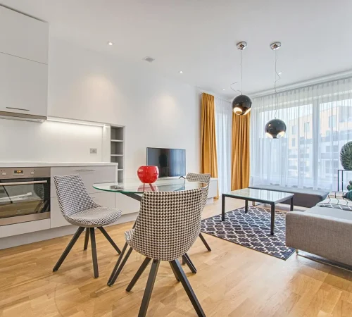 Elegant Scandinavian-style living room and kitchen featuring modern furniture and decor.